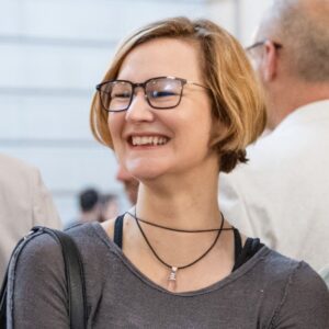 Headshot of woman with glasses and necklace
